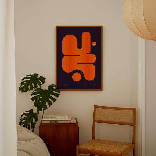 Abstract orange and black art piece on a wall above a wooden side table with books and a plant.
