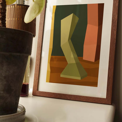 Modern art poster with geometric shapes in vintage colours, framed and displayed on a table next to a plant and decorative items